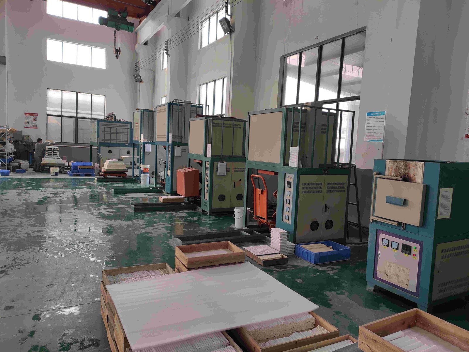 A row of firing furnaces and setter boards down the length of the bay