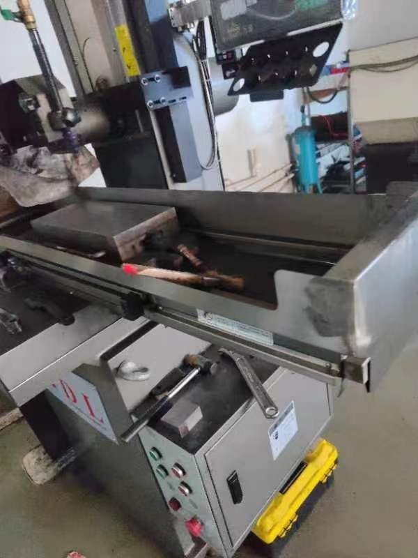 A machine tool with its work tank open, the wire head and the control panel in view